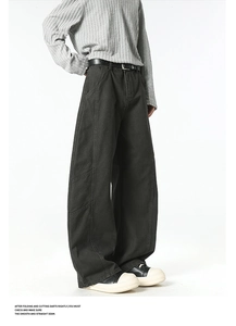 Detail view of charcoal cargo pants with structural seam stitching and wide-leg silhouette