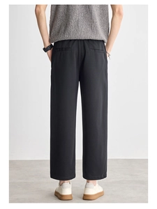 Men's black straight-leg trousers showing back view and slim fit drape texture