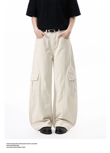 Detail view of beige wide-leg cargo pants with large side pockets and panels