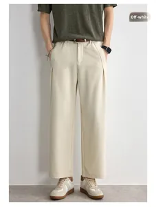 Detail of off-white textured straight-leg pants showing premium drape and front pleats
