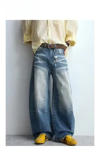 Detail of washed retro blue wide-leg denim jeans with vintage whiskering and pleated seams