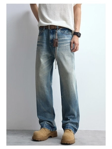 Detail of blue wash denim with whiskering effect and straight leg fit on male model