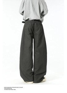 Rear view of wide-leg dark cargo trousers with large back pockets and belt detailing