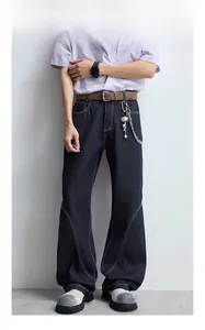 Détail d'un jean en denim bleu foncé avec surpiqûres et coutures incurvées
