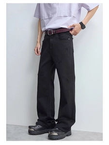 Détails des éléments usés et de la texture sur le jean évasé noir pour hommes