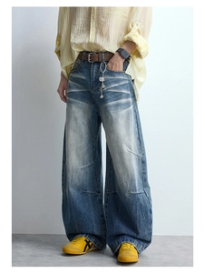 Detail of vintage washed wide-leg jeans with cat-whisker fading and knee panels