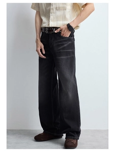 Détail de jean large pour homme avec surpiqûres contrastées et délavage vintage