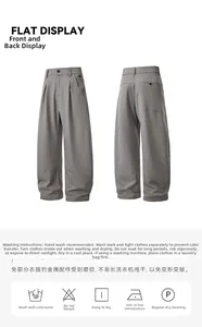 Détails du pantalon large gris montrant la taille plissée et la texture du tissu sergé
