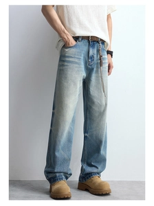 Detailed view of vintage washed blue jeans with cat whiskers and straight-leg fit