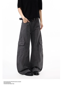 Detail of charcoal grey cargo pants with structural stitching and side flap pockets