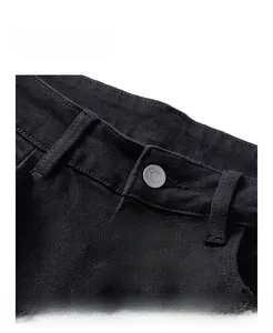 Détails de la taille d'un jean slim noir avec bouton métallique et passants de ceinture