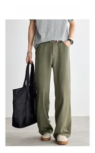 Dettaglio dei pantaloni sportivi dritti verde oliva con trama verticale e cucitura