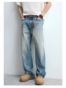 Detail of vintage blue washed denim jeans featuring cat whiskers and straight leg fit
