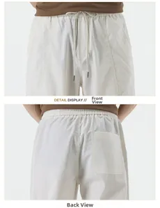 Detail view of elastic drawstring waist and pocket on white Lyocell casual pants
