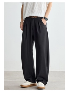 Gros plan d'un pantalon noir droit à plis avec un drapé fluide pour hommes