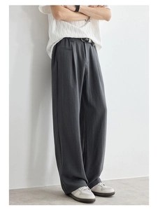 Close-up of pleated dark grey wide-leg trousers with premium Lyocell texture