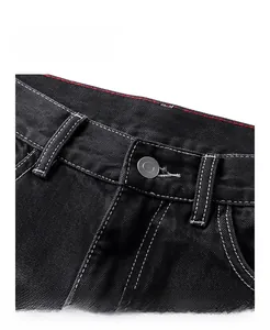 Détail de la taille du jean noir avec coutures blanches et passepoil intérieur rouge
