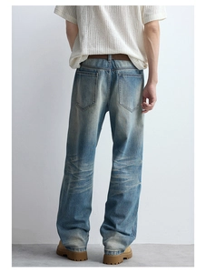 Detailed back view of vintage wash blue denim jeans showing whiskered fading and pockets