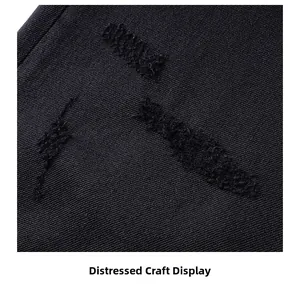 Vue macro des détails usés et de la texture sergé sur un pantalon en jean noir