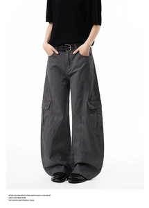 Detail of dark grey wide-leg cargo pants with large side flap pockets and studded belt
