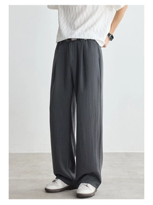 Macro detail of dark grey Lyocell Tencel trousers showing draped fabric texture