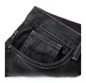 Détail de la poche avant en jean noir avec surpiqûres blanches et rivets métalliques