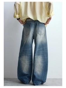 Macro detail of baggy jeans with heavy wash effects and symmetrical back pocket design