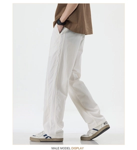 Detail shot of white men's leisure pants with breathable texture and loose straight cut