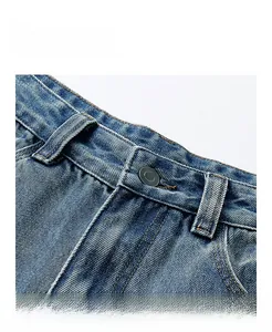 Close-up of waistband on vintage washed blue jeans with metal button and yellow stitching