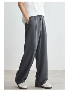 Close-up of dark grey Lyocell loose trousers with a draped texture and wide leg fit