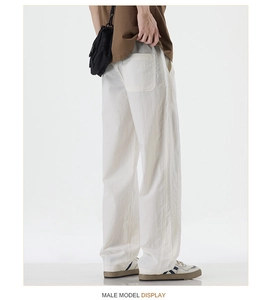 Detail view of white wide-leg trousers showing breathable fabric and rear patch pocket design