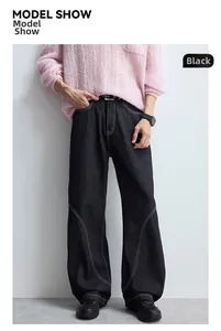 Détail d'un jean large noir avec surpiqûres contrastées blanches et coupe ample