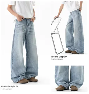 Detail of light blue washed denim with vintage cat-whisker effect and loose straight leg cut