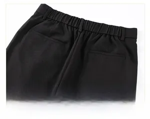 Détail du pantalon noir en soie glacée avec taille élastique et poches passepoilées
