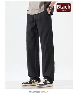 Detail of black loose-fit straight pants with drawstring waist and stitched seams