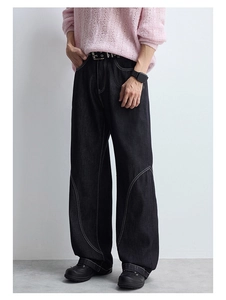 Détail du pantalon en jean noir ample avec surpiqûres contrastées et coupe large tendance