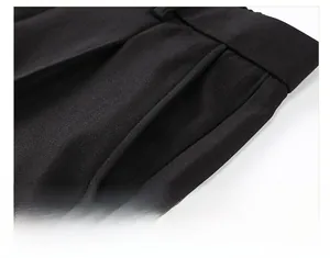 Gros plan d'un pantalon en soie glacée noire montrant la poche diagonale et le tissu sergé