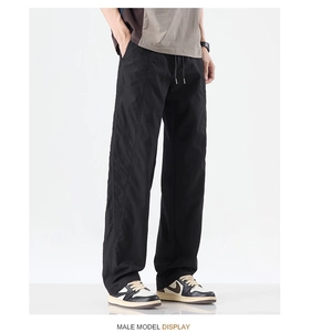 Detail of black loose-fit straight pants with drawstring elastic waist and ice silk fabric