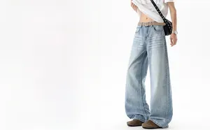 Detail of light blue wide-leg jeans with vintage cat-whisker wash and brown belt