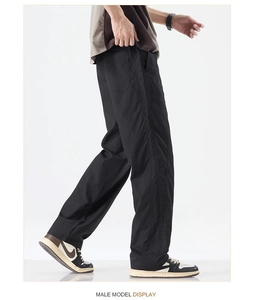 Detail of black straight-leg trousers in lightweight ice silk fabric on male model
