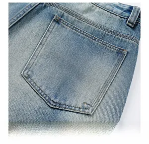 Close-up of back pocket details and yellow stitching on light blue washed denim jeans