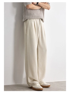 Detail of loose beige Lyocell trousers showing the textured fabric and relaxed fit