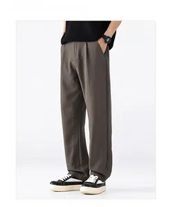 Détail du pantalon large marron pour homme avec une texture fluide et une coupe droite