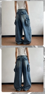 Detail shot of vintage wash denim cargo pants with large side pockets and baggy fit
