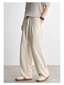 Detail of loose fit off-white Lyocell trousers with textured fabric and front pleats