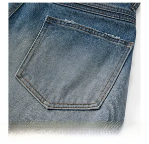 Close-up of vintage blue denim back pocket with distressed frayed edge detail