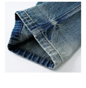 Close-up of high-quality denim hem stitching and vintage washed texture on blue jeans