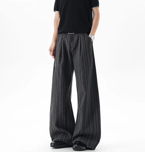 Detailed view of grey striped wide-leg trousers with vertical pleats and draped fabric