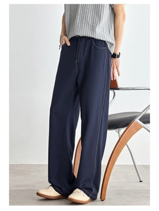 Dettaglio dei pantaloni casual blu scuro da uomo con cuciture bianche a contrasto e gamba larga