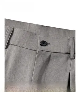 Détail de la taille du pantalon gris foncé montrant les boutons et la texture du tissu sergé